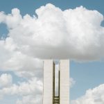 Edifício do Congresso Nacional em Brasília sob céu com formações de nuvens.