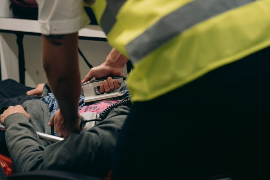 Paramédicos prestam atendimento urgente a um paciente deitado em uma maca.