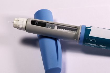 Caneta de aplicação de semaglutida sobre fundo neutro.