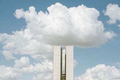 Edifício do Congresso Nacional em Brasília sob céu com formações de nuvens.