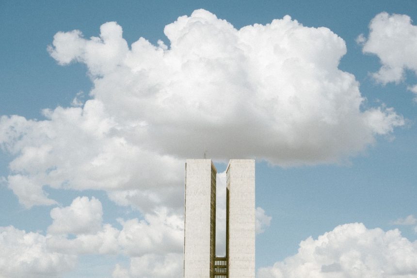 Edifício do Congresso Nacional em Brasília sob céu com formações de nuvens.