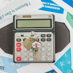 Calculadora sobre documentos de financiamento imobiliário, representando o planejamento financeiro para compra de um imóvel