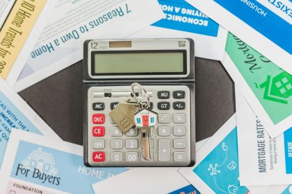 Calculadora sobre documentos de financiamento imobiliário, representando o planejamento financeiro para compra de um imóvel